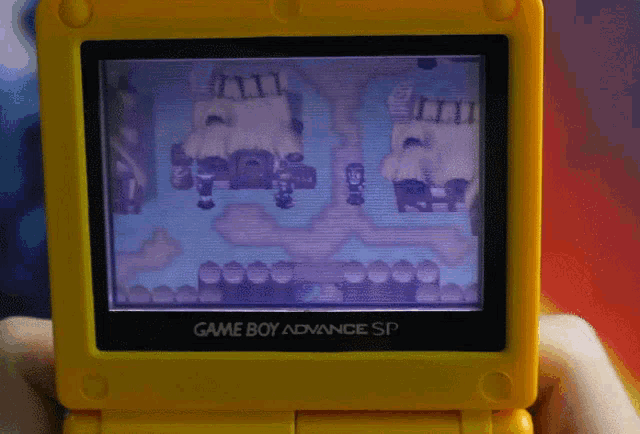 somebody playing golden sun on a yellow gameboy advance sp