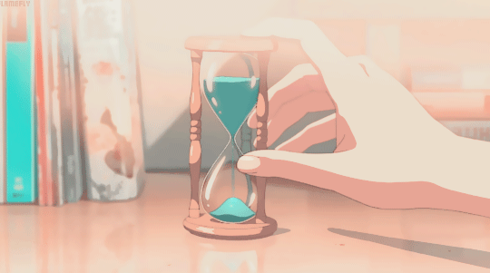 somebody holding an hourglass as the sand falls